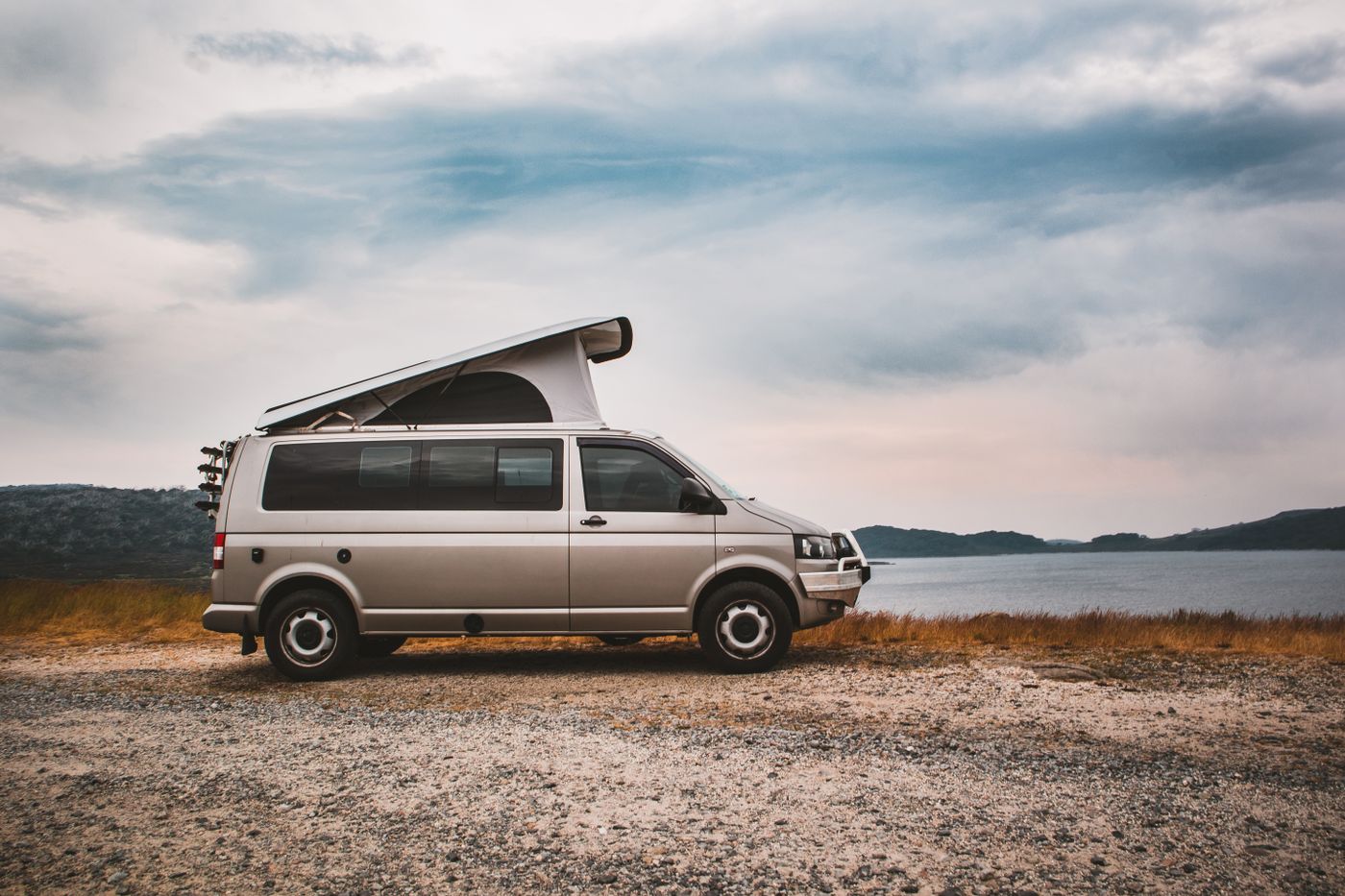 Motorhome beside water under dramatic sky